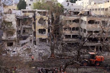 Des secouristes se tiennent au milieu des décombres d'un immeuble endommagé à Tel-Aviv, suite à une attaque de missiles iraniens le 16 juin 2025. ©AFP